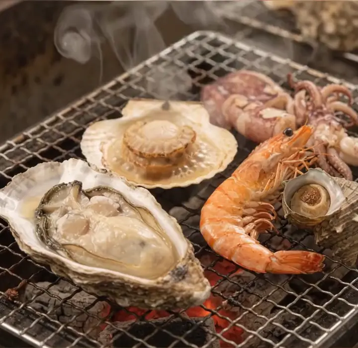 牡蠣・ホタテ・エビが炭火で焼け、湯気が立つイメージ動画
